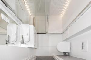 a white bathroom with a toilet and a sink at Apartament Bielany 3 min from metro with 5-meals per day customisable diet catering and free parking in Warsaw