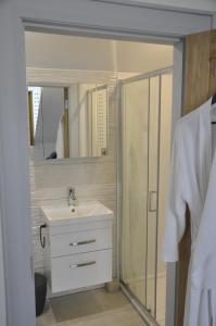 a white bathroom with a sink and a shower at Hillside Luxury Bed & Breakfast in Ballycastle