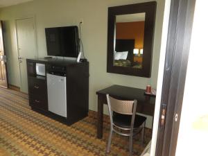 a room with a desk and a television and a table and chair at Ocean Gate Inn in Santa Cruz