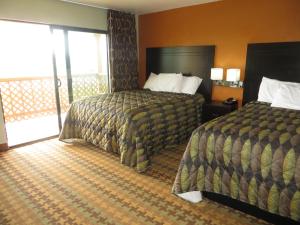 a hotel room with two beds and a balcony at Ocean Gate Inn in Santa Cruz