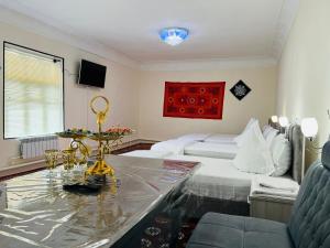 a living room with a bed and a table in a room at Nemo Guest House in Bukhara