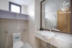 ein Badezimmer mit einem WC, einem Waschbecken und einem Spiegel in der Unterkunft Kim Ngan Phat Luxury Villa in Đà Nẵng