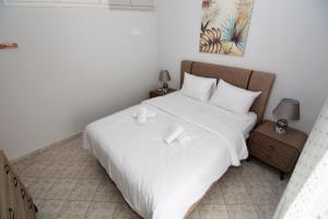 a white bed with white sheets and pillows at Bella Vista in Kavála