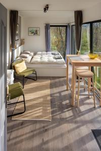 a bedroom with a bed and a desk and a table at Stüble Kabinok in Somogyhárságy