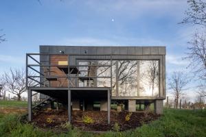 a glass house with a staircase in a field at Stüble Kabinok in Somogyhárságy