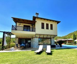 a large house with a yard with a pool at Villa Oceanview Vicky in Pefkochori