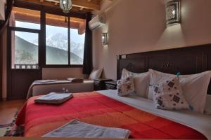 una camera da letto con un letto grande con una coperta rossa di DAR ATLAS CHARME a Imlil