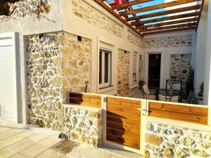 a stone house with a wooden fence on a patio at luxury house in Ierápetra