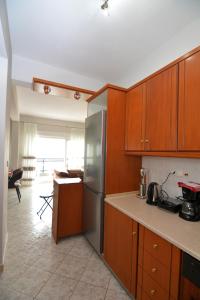 a kitchen with wooden cabinets and a stainless steel refrigerator at Bella Vista in Kavála