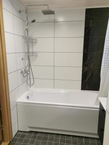 a white bath tub in a bathroom with a shower at Lion Stay in Tartu