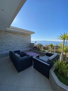 a patio with couches and a view of the ocean at VIzzavona piscine et jacuzzi in Ajaccio