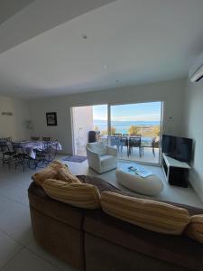 a living room with a large couch and a television at VIzzavona piscine et jacuzzi in Ajaccio