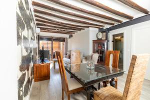 Apartamentos Vino Tinto في Adahuesca: غرفة طعام مع طاولة وكراسي زجاجية