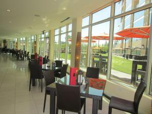 un comedor con mesas, sillas y ventanas en University Plaza Waterfront Hotel, en Stockton