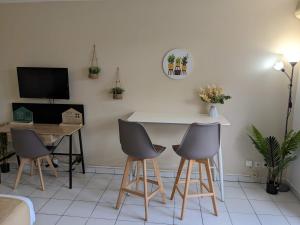 uma sala de estar com uma mesa e três cadeiras em Topaze Pei - T1 - 2 personnes em Saint-Denis