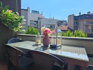 a table with a vase of flowers on a balcony at Cozy Apartment with large exclusive terrace in Milan