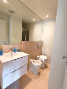 a bathroom with a toilet and a sink and a mirror at Cozy Apartment with large exclusive terrace in Milan