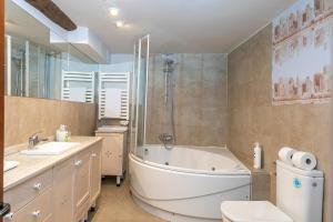 a bathroom with a tub and a toilet and a sink at Apartamentos Vino Tinto in Adahuesca