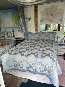 a bedroom with a bed with a blue and white comforter at Na in Ramsgate