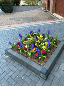 un jardin de fleurs colorées sur un trottoir en briques dans l'établissement Holiday Home in Cardiff which sleep 5 and we try and make it a home from home, à Cardiff