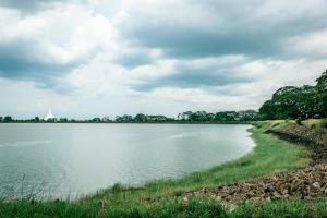 a view of a lake with a church in the distance at Aspirations Holiday Villas in Anuradhapura