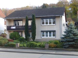 a house with bushes and trees in front of it at Ferienwohnung Regina Müller in Bad Karlshafen