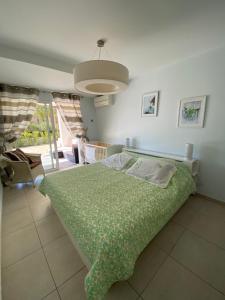 - une chambre avec un lit et une couverture verte dans l'établissement Villa cote plage, à Ajaccio