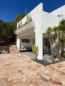 une maison blanche avec une terrasse et un cactus dans l'établissement Villa cote plage, à Ajaccio
