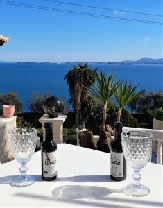 two bottles of wine and two glasses on a table at Stefanosplace ApartHotel Sea View in Barbati