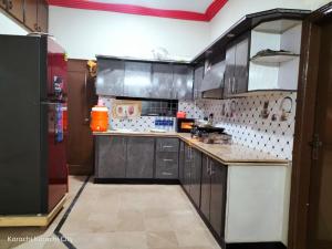 a kitchen with black cabinets and an orange appliance at SUBHAN PALACE Near Millennium Mall karachi in Karachi