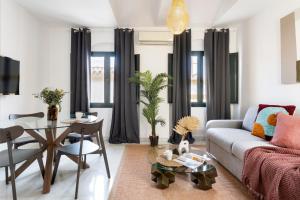 塞維利亞的住宿－Suites Maestranza - Refinadores by Magno Apartments，客厅配有沙发和桌子