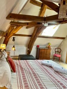 Schlafzimmer mit einem großen Bett mit Holzbalken in der Unterkunft Domaine de La Vove in Corbon