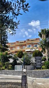 un panneau devant un bâtiment planté de palmiers dans l'établissement Stefanosplace ApartHotel Sea View, à Barbati