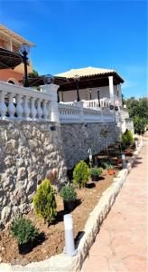 a stone wall with plants in front of a house at Stefanosplace ApartHotel Sea View in Barbati