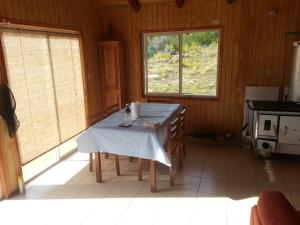 uma cozinha com uma mesa com uma toalha de mesa em Patagonia 47g em Aldana