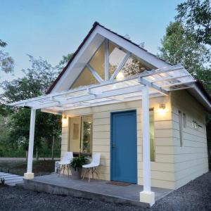 a tiny house with a blue door and a pergola at Casita Bohemia (Tiny House) in Fortuna