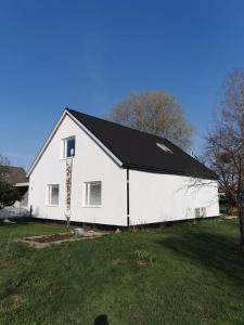 a white barn with a black roof in a yard at Villa i Ruda Högsby kommun in Ruda