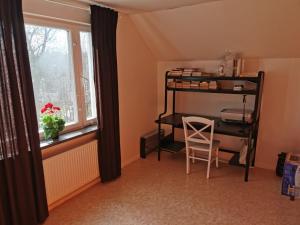 a room with a bunk bed and a chair and a window at Villa i Ruda Högsby kommun in Ruda