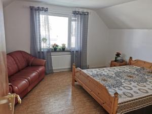 a bedroom with a bed and a couch and a window at Villa i Ruda Högsby kommun in Ruda