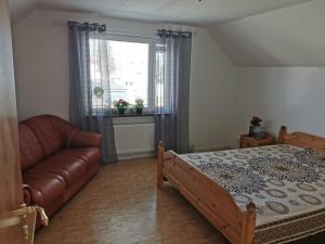 - une chambre avec un lit, un canapé et une fenêtre dans l'établissement Villa i Ruda Högsby kommun, à Ruda