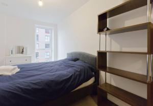 1 dormitorio con cama y estante para libros en 2-Bed Apartment only 15 mins from Central London, en Londres