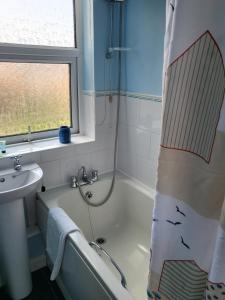 a bathroom with a bath tub and a sink at The Bluebell Guest House in Bridlington