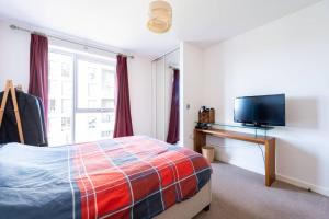 1 dormitorio con 1 cama y TV de pantalla plana en 2-Bed Apartment only 15 mins from Central London, en Londres