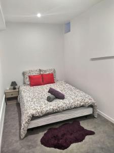 um quarto com uma cama com duas almofadas vermelhas em Tout Confort Appart 7 em Évreux