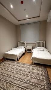 2 camas en una habitación con alfombra en ماربيلا en Al Khobar