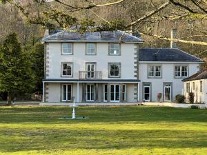 a large white house with a fountain in the yard at Lovelady Shield Country House Hotel in Alston