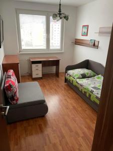 um quarto com uma cama, um sofá e uma mesa em Apartman Gufo em Kysucké Nové Mesto