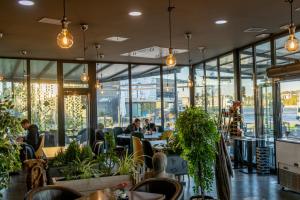 a restaurant with people sitting at tables and windows at Hotel Moment in Velika Plana