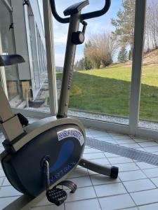 an exercise bike sitting on the floor next to a window at Dreisessel Dreiländereck Pool Sauna in Neureichenau