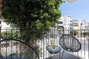 two chairs and a table on a balcony at Gordon Beach by Five Stay in Tel Aviv